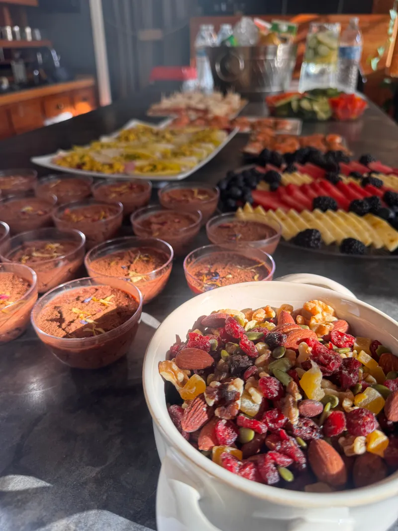 A buffet spread of mousse cups, fresh fruit, and endive spears