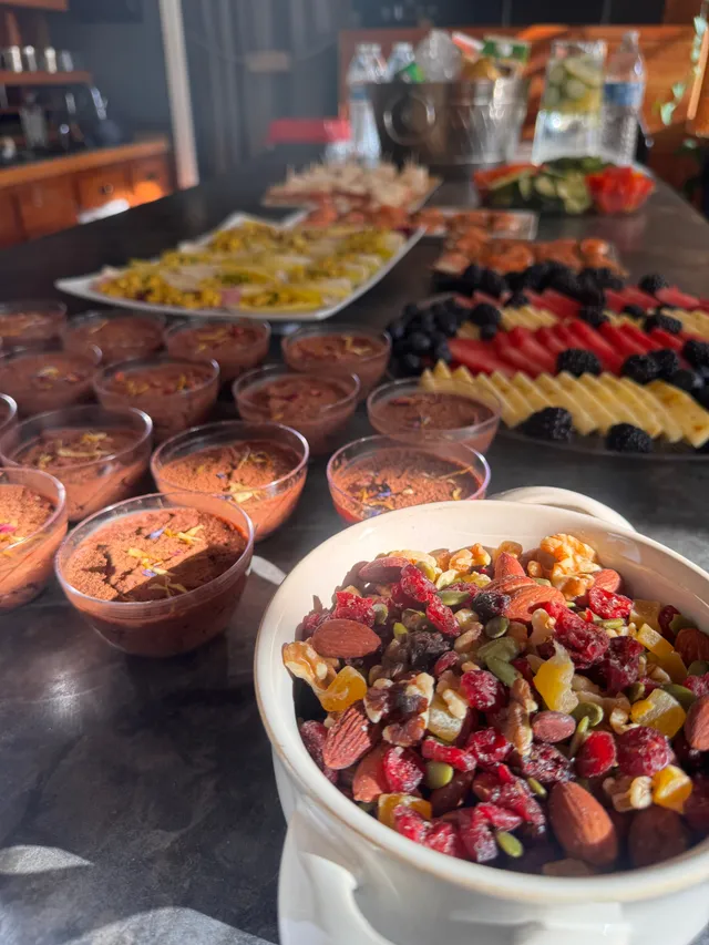 A buffet spread of mousse cups, fresh fruit, and endive spears