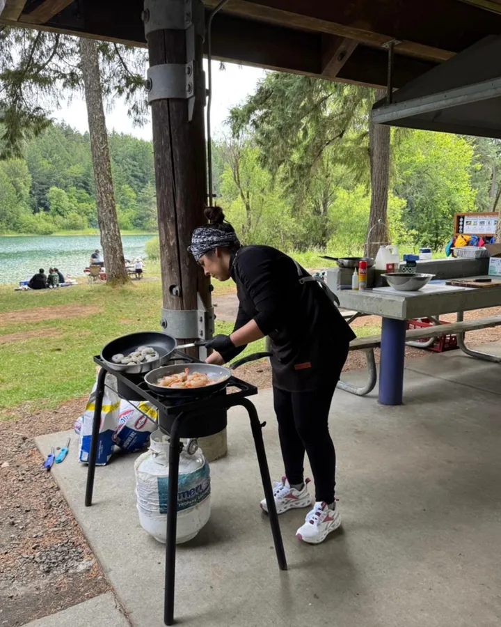 Cooking over a propane burner outdoors by a lake